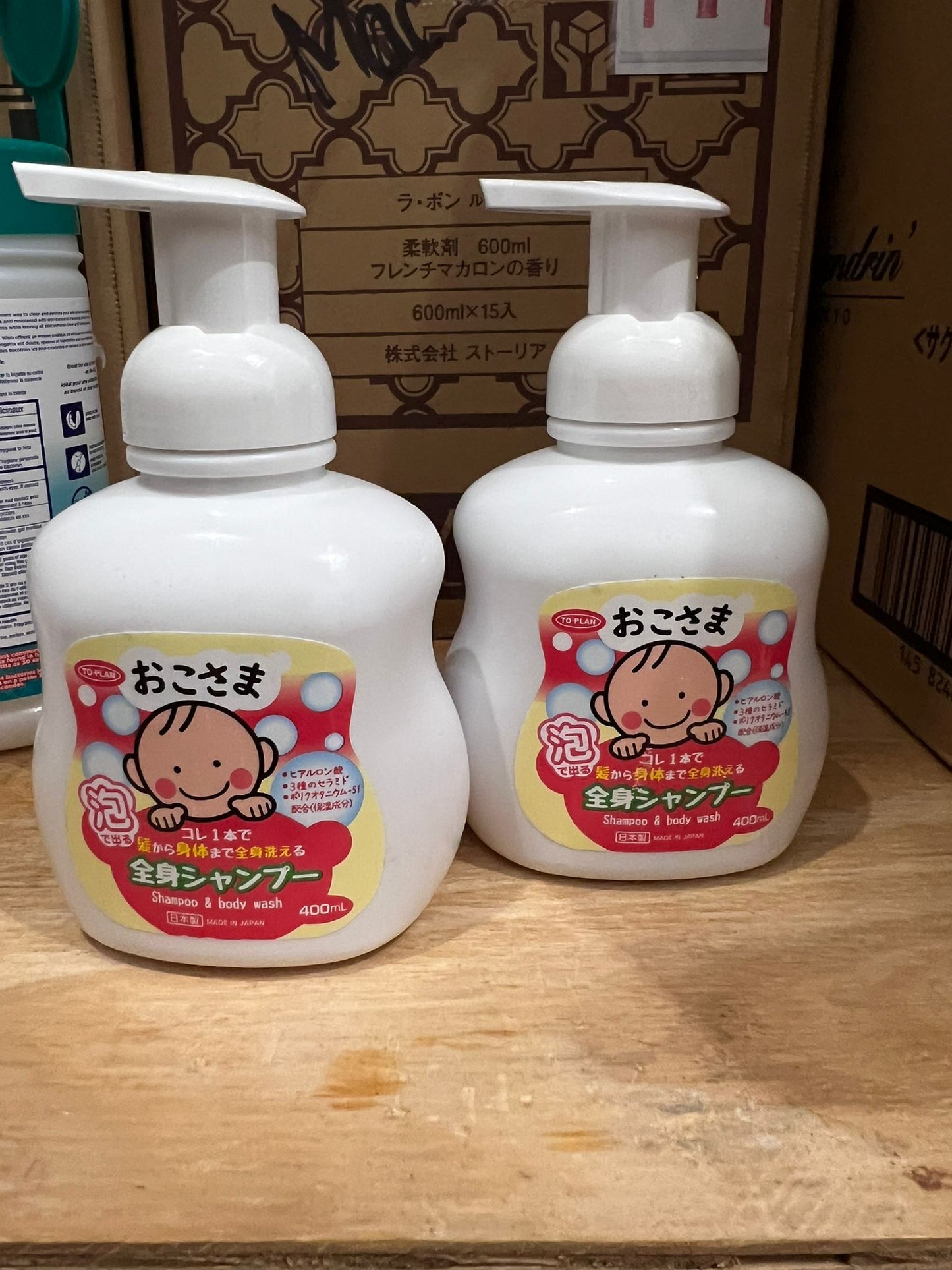 Two bottles of gentle baby and kid foaming hair and body wash on wooden table