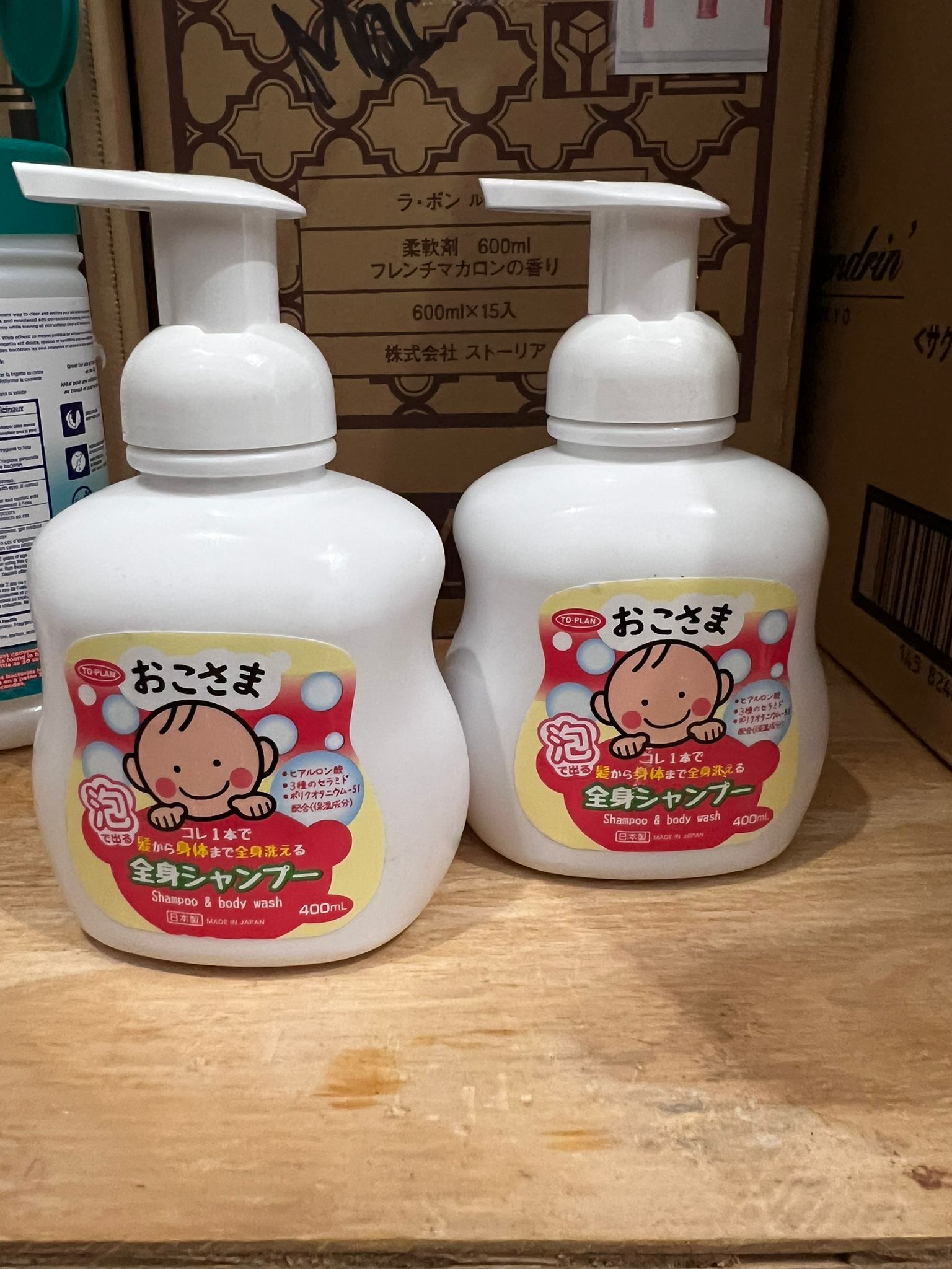 Two bottles of gentle baby and kid foaming hair and body wash on wooden table